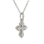 White gold mini cross pendant with sparkling diamond accents on chain.