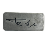 Limited edition signed aluminum bar with black signature on matte silver surface.