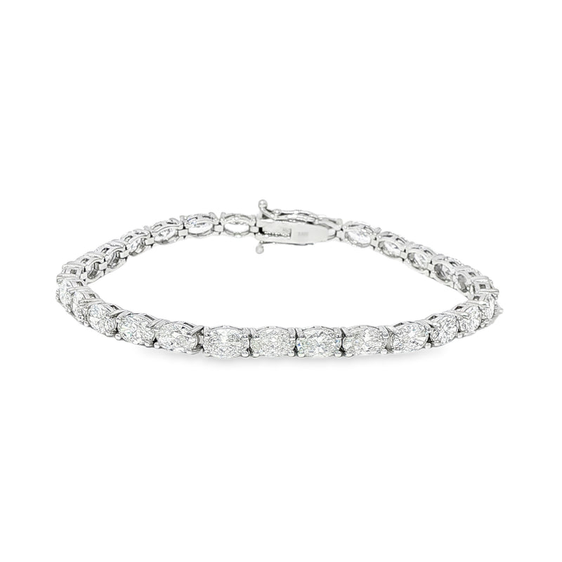White gold tennis bracelet with oval-cut diamonds in a linked setting.