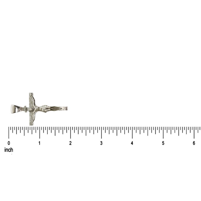 Small silver crucifix pendant with detailed Jesus figure on inch ruler background.