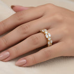 Yellow gold cluster diamond ring with oval diamonds in a wrap-around design on hand.