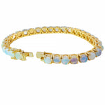 Yellow gold tennis bracelet with oval opal gemstones in bezel settings, unisex design.