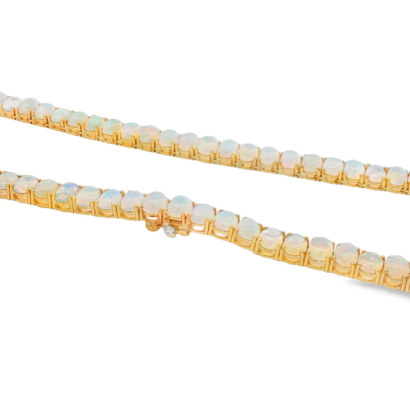 Yellow gold chain necklace with luminous round opal gemstones in tennis style design.
