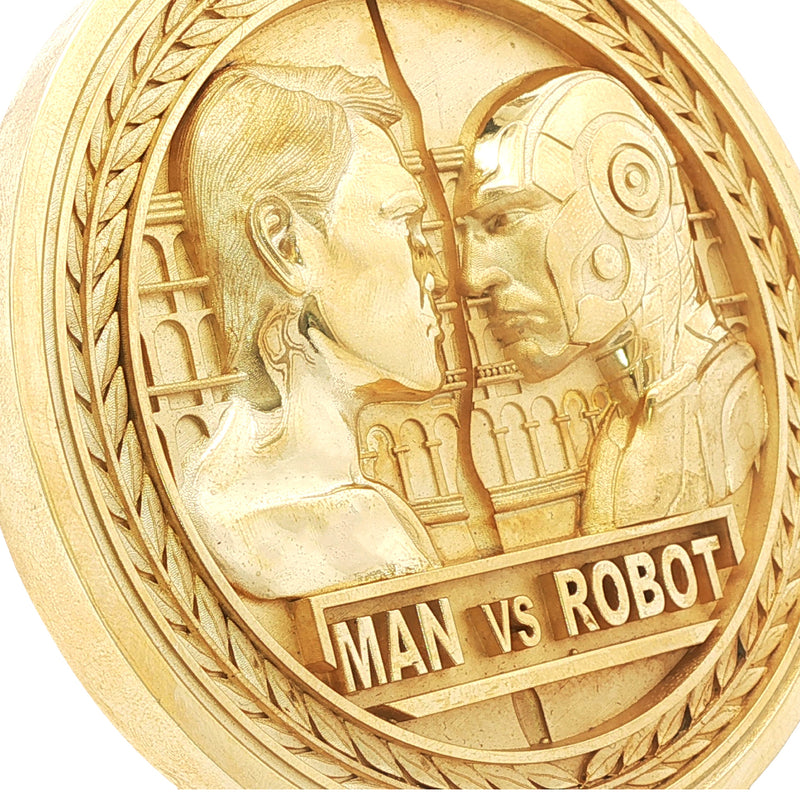 Gold-tone round medal pendant with detailed man and robot faces and "MAN VS ROBOT" text.