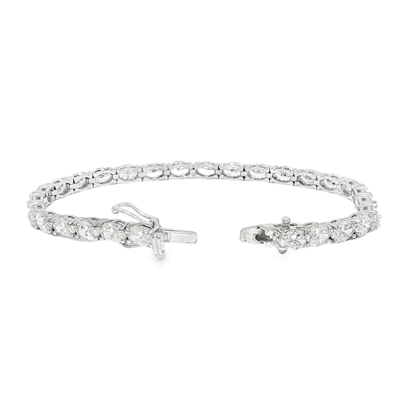 White gold tennis bracelet with oval-cut diamonds in a linked setting.