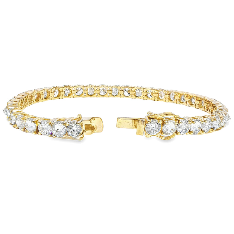 Yellow gold tennis bracelet with alternating upside-down round diamonds in secure clasp.