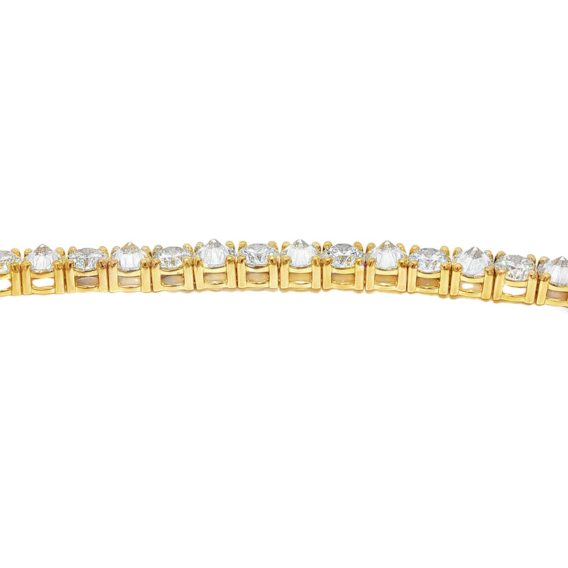 Yellow gold tennis bracelet with alternating upside-down round diamonds in secure clasp.