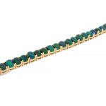 Gold tennis bracelet with round galaxy black opal gemstones in a secure setting.