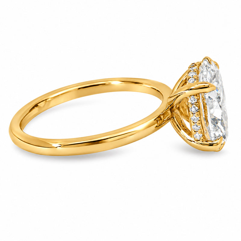18K yellow gold engagement ring featuring a 5 carat oval lab grown diamond, four claw prongs, a delicate hidden halo, and a polished solitaire band