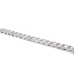 White gold tennis bracelet with alternating upside down round diamonds in a sleek setting.