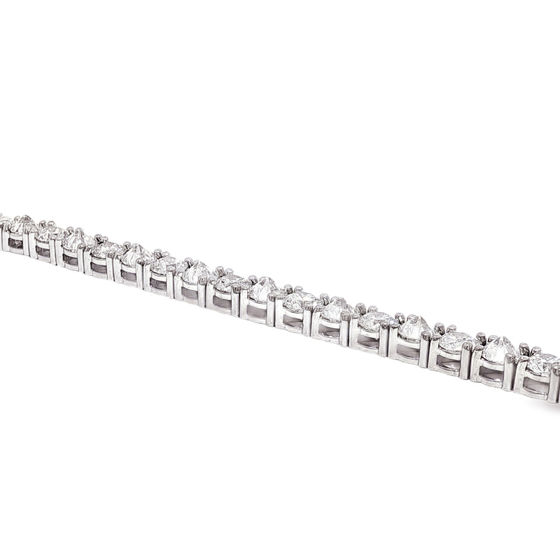 White gold tennis bracelet with alternating upside down round diamonds in a sleek setting.