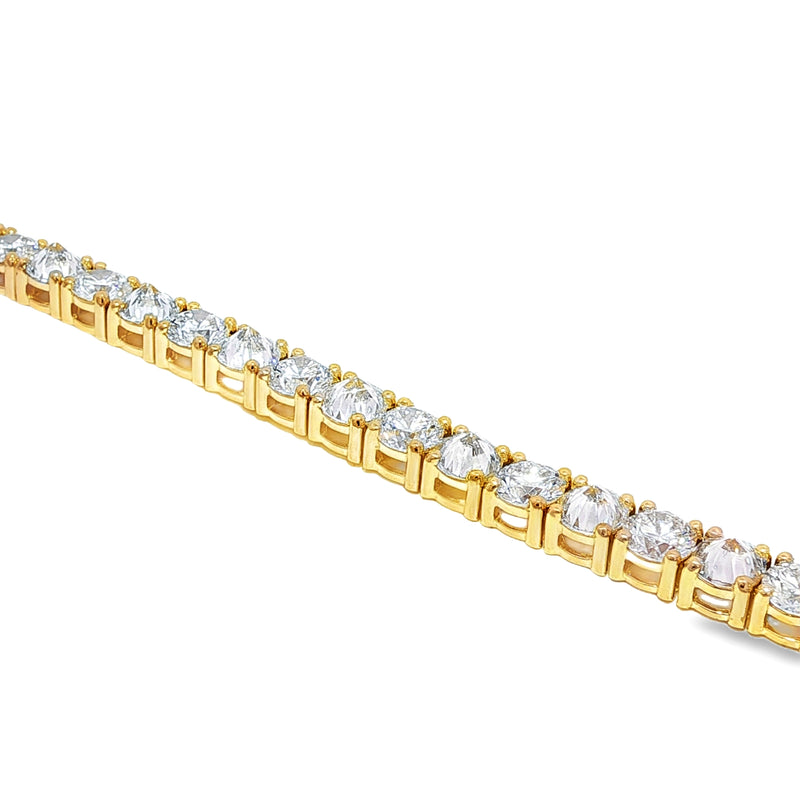 Yellow gold tennis bracelet with alternating upside-down round diamonds in secure clasp.