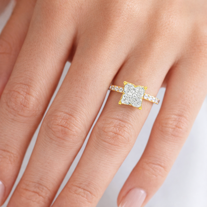 Yellow gold engagement ring with square flower-cut diamond and diamond-studded band.