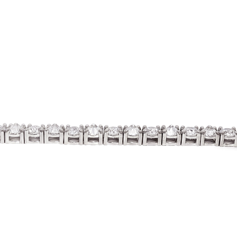 White gold tennis bracelet with alternating upside down round diamonds in a sleek setting.