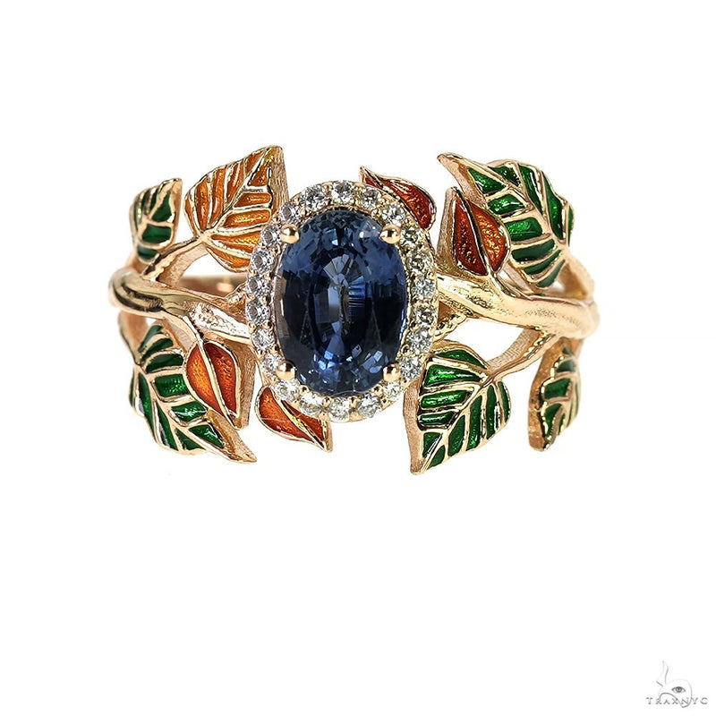 Yellow gold ring with oval blue sapphire surrounded by diamond accents and enamel leaves