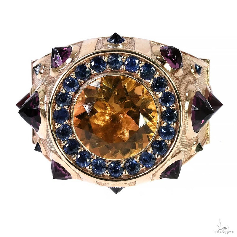 Yellow gold ring with large central amber sapphire surrounded by smaller blue sapphires and purple accents