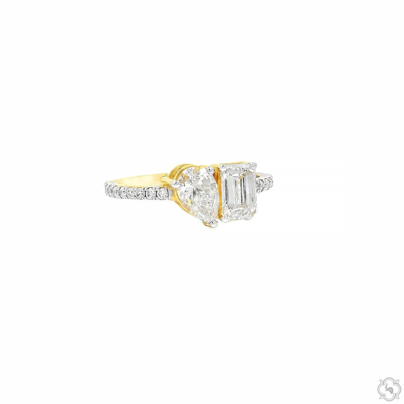 Yellow gold engagement ring with pear-shaped and emerald-cut diamonds on diamond band