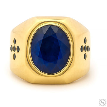 Yellow gold men's ring with large oval deep blue sapphire and black diamond accents on sides.