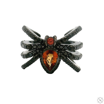 Black silver spider ring with orange gemstone body and detailed textured legs.
