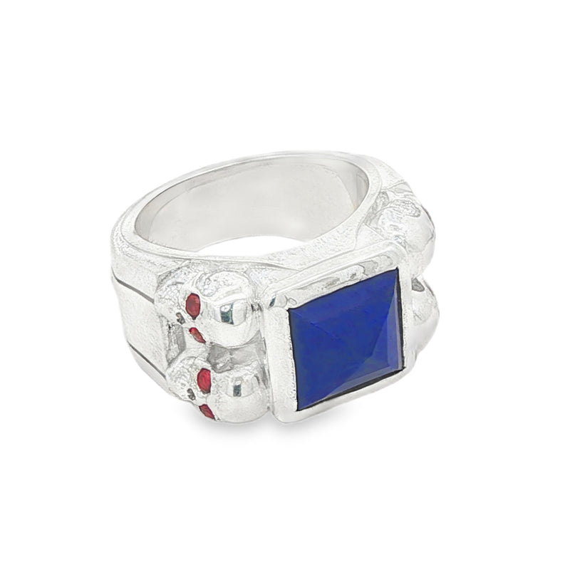Silver ring with square blue lapis, skull details, and small red sapphires.