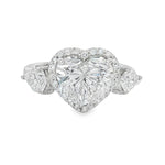 White gold engagement ring with heart-shaped diamond center and two side stones.