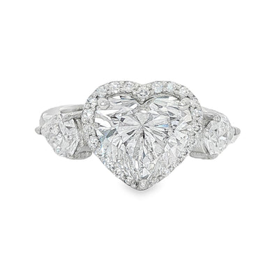 White gold engagement ring with heart-shaped diamond center and two side stones.