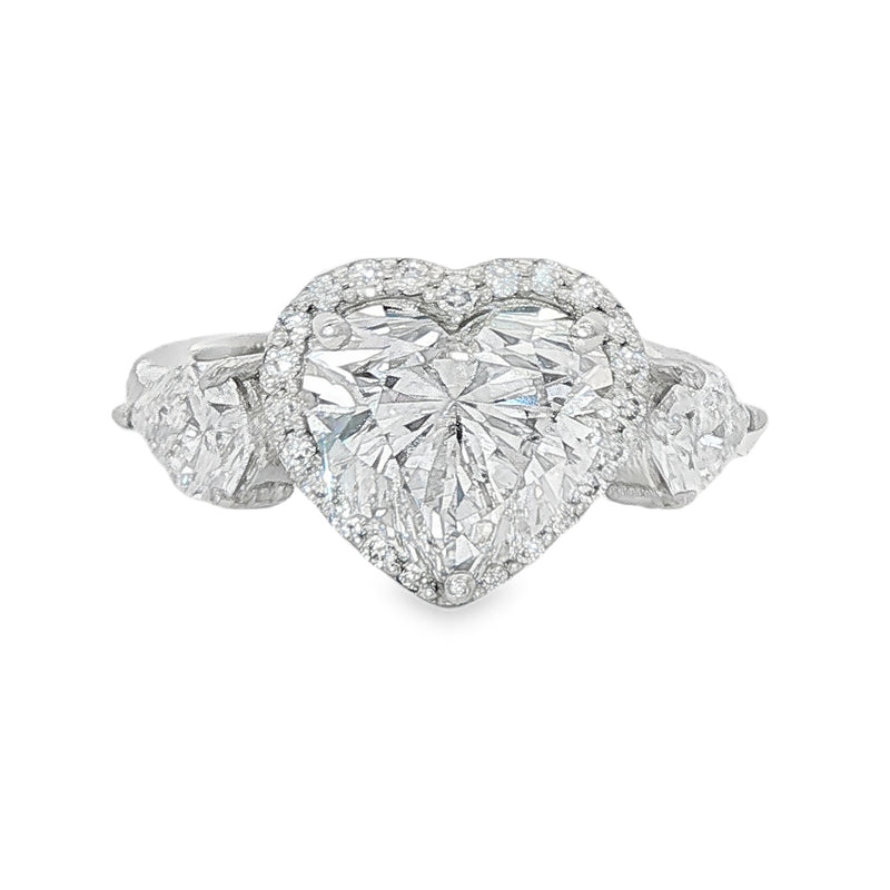 White gold engagement ring with heart-shaped diamond center and two side stones.