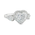White gold engagement ring with heart-shaped center diamond and three-stone halo design.