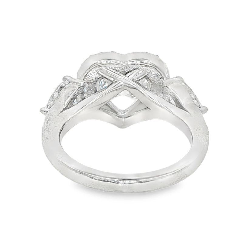 White gold engagement ring with heart halo and three diamond stones, elegant design.