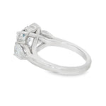 White gold three stone engagement ring with heart-shaped diamond center and halo accents.