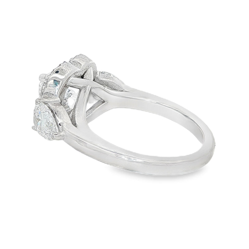 White gold three stone engagement ring with heart-shaped diamond center and halo accents.