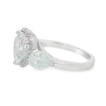 White gold three-stone engagement ring with heart-shaped and pear-cut diamonds.