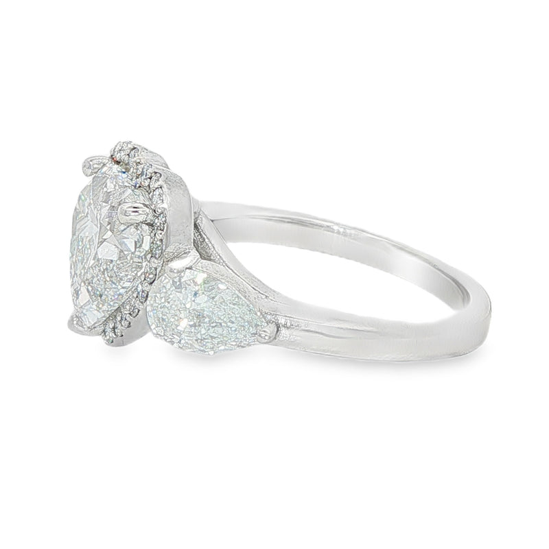 White gold three-stone engagement ring with heart-shaped and pear-cut diamonds.
