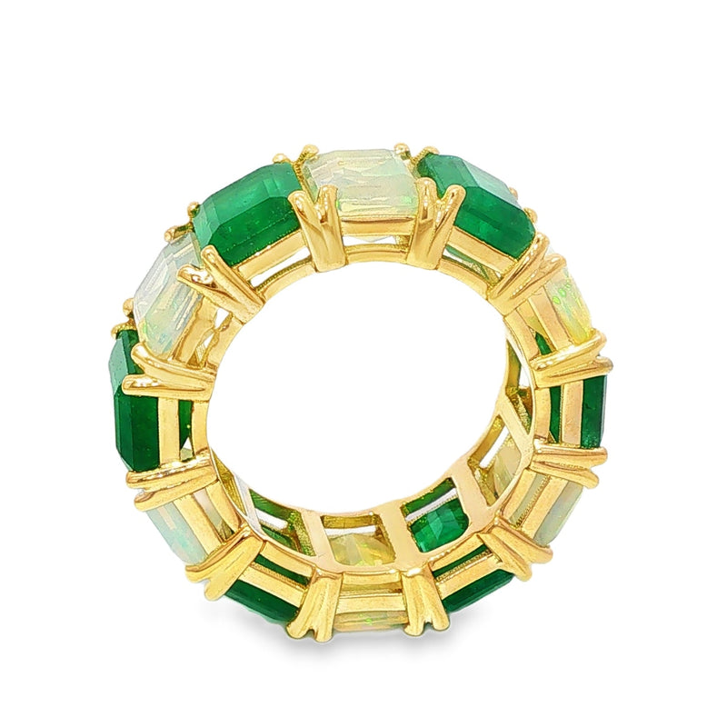 Yellow gold eternity ring with alternating emerald and rectangular opal gemstones.