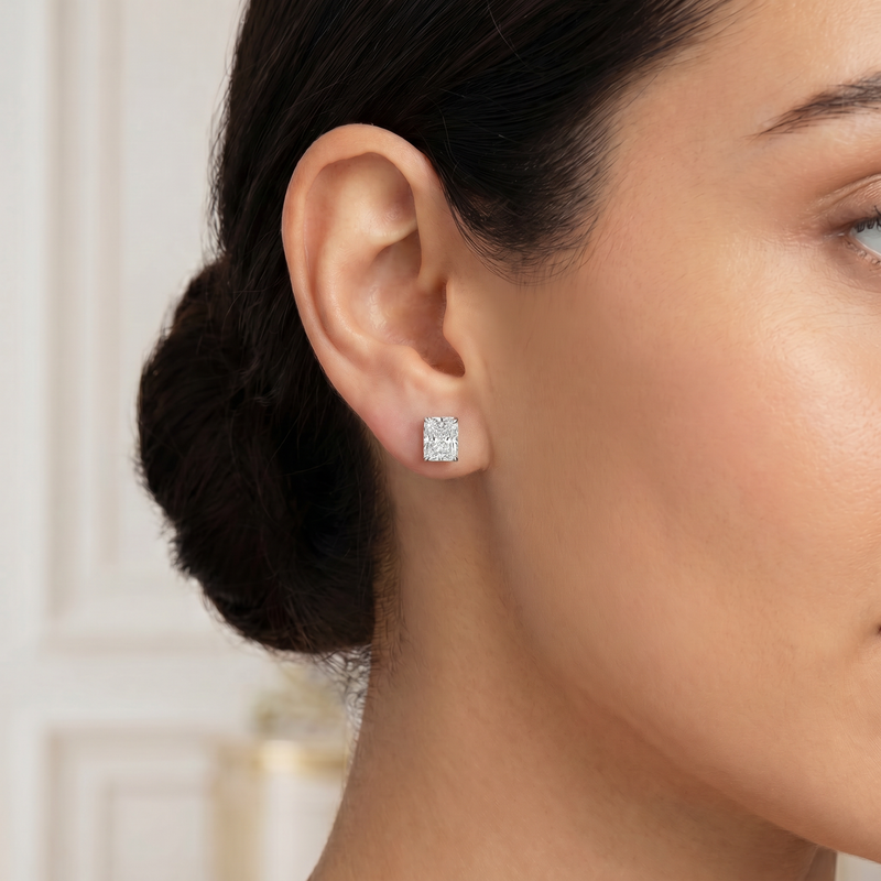 Pair of radiant cut diamond stud earrings with four-prong white gold setting, brilliant facets