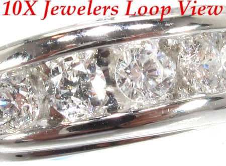 Men's white gold wedding band with channel-set round diamonds across the center.