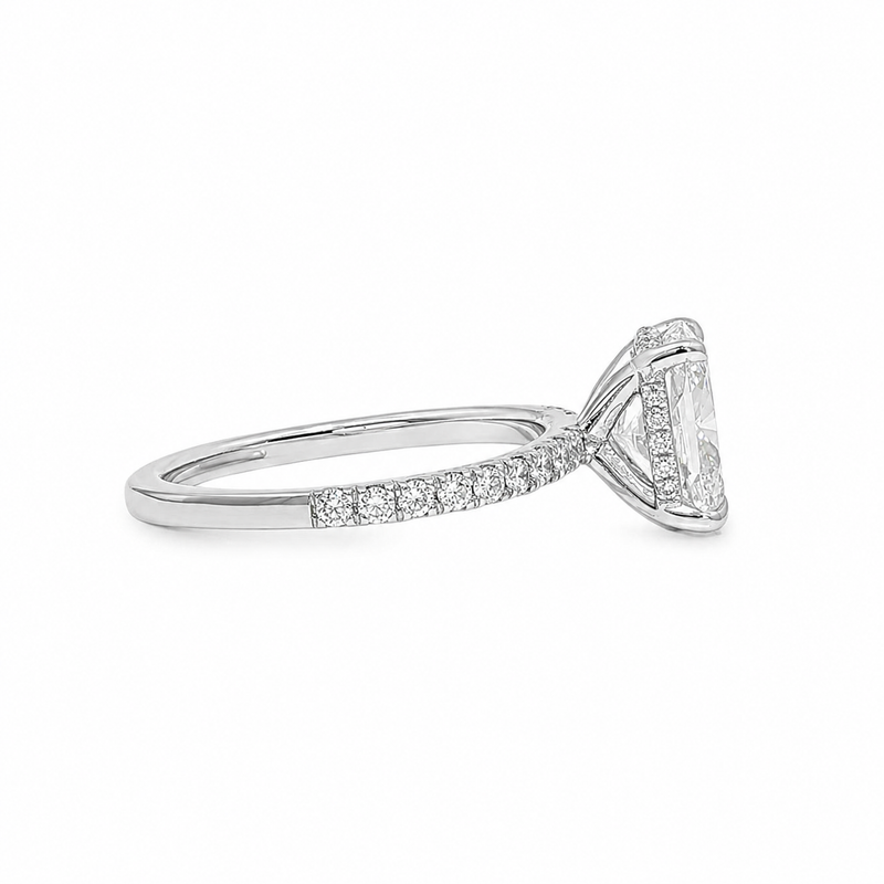 White gold engagement ring with round center diamond and small side diamonds on band.