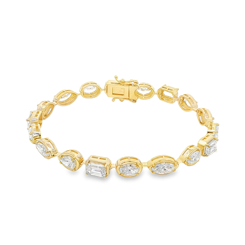 Yellow gold tennis bracelet featuring multi-shape sparkling diamonds in assorted cuts.