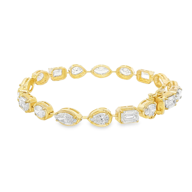 Yellow gold tennis bracelet featuring multi-shape sparkling diamonds in assorted cuts.