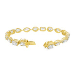 Yellow gold tennis bracelet featuring multi-shape sparkling diamonds in assorted cuts.
