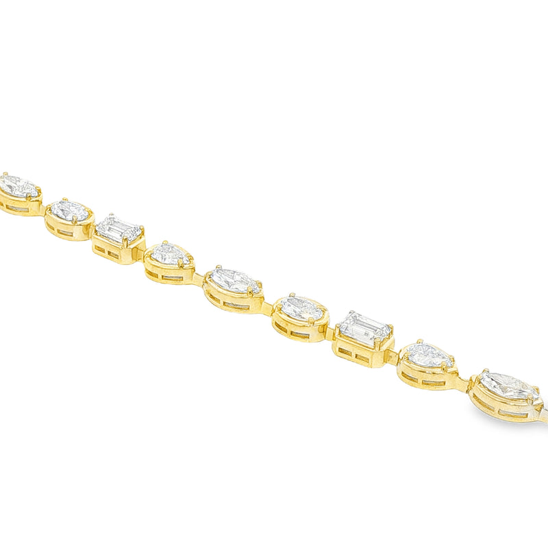 Yellow gold tennis bracelet featuring multi-shape sparkling diamonds in assorted cuts.