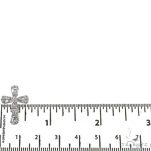 White gold baguette diamond cross pendant with chain, next to ruler showing size under 1.5 inches