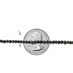 Black diamond bead bracelet with faceted round beads, shown against a quarter for scale.