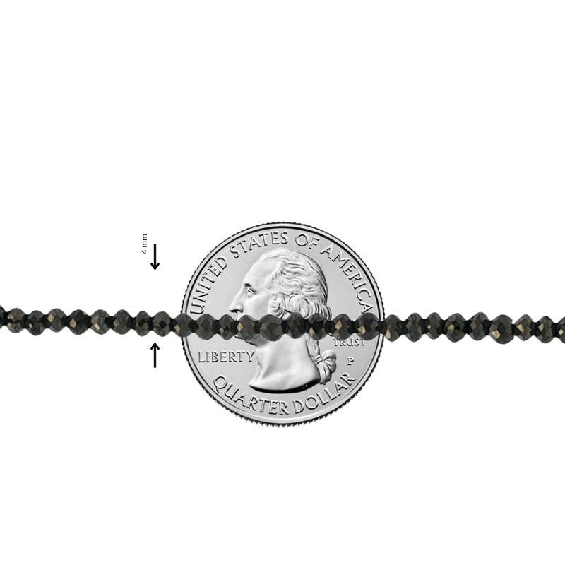 Black diamond bead bracelet with faceted round beads, shown against a quarter for scale.