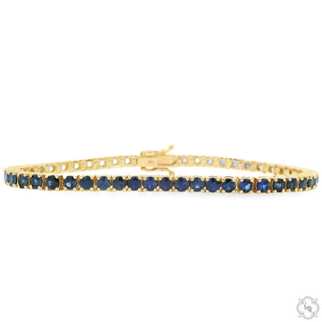 Yellow gold tennis bracelet with round blue ombre sapphire gemstones.