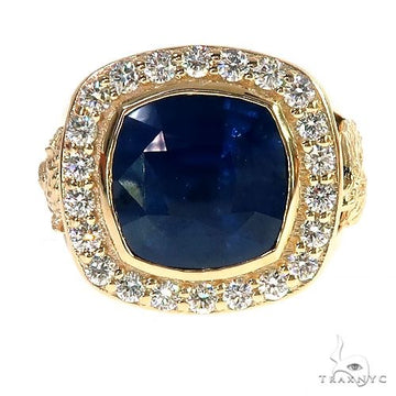 Yellow gold ring with cushion-cut blue sapphire surrounded by round diamonds.