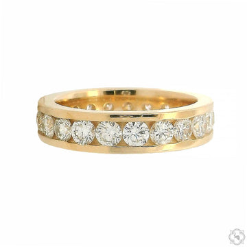 Yellow gold channel set diamond eternity band with round brilliant diamonds.