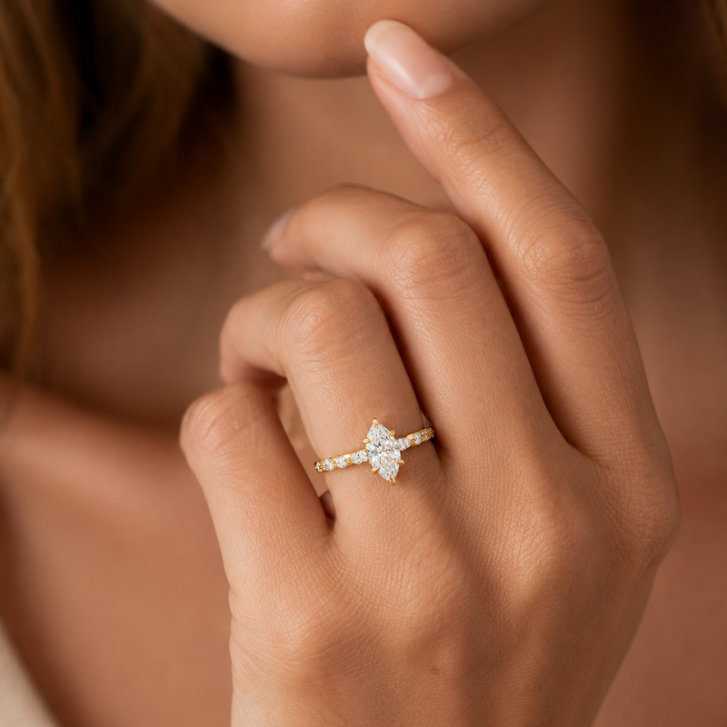 14k gold ring with 1 ct marquise diamond and pavé band on woman's hand.