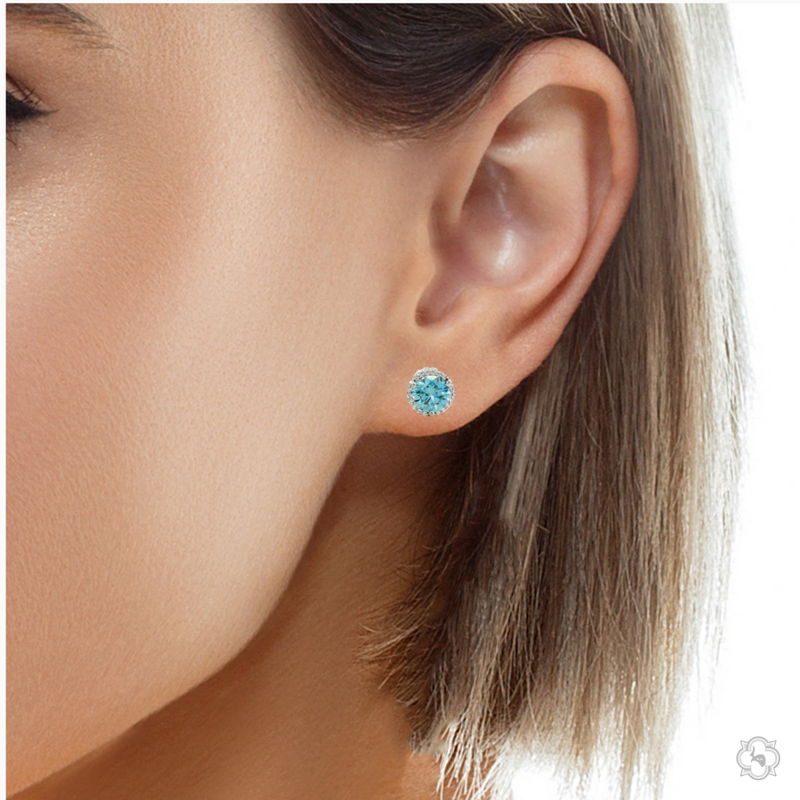 Round blue gemstone stud earrings with diamond halo in white gold setting.