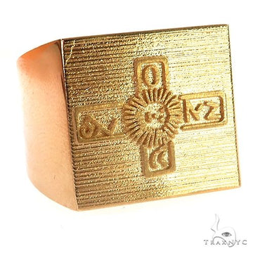Square yellow gold ring with engraved ornate cross design on textured surface.